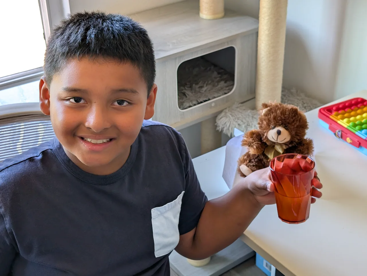 Ray smiling at home while holding Mr. Bearry