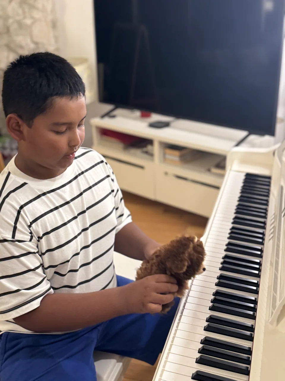Ray holding Mr. Bearry while sitting at the piano