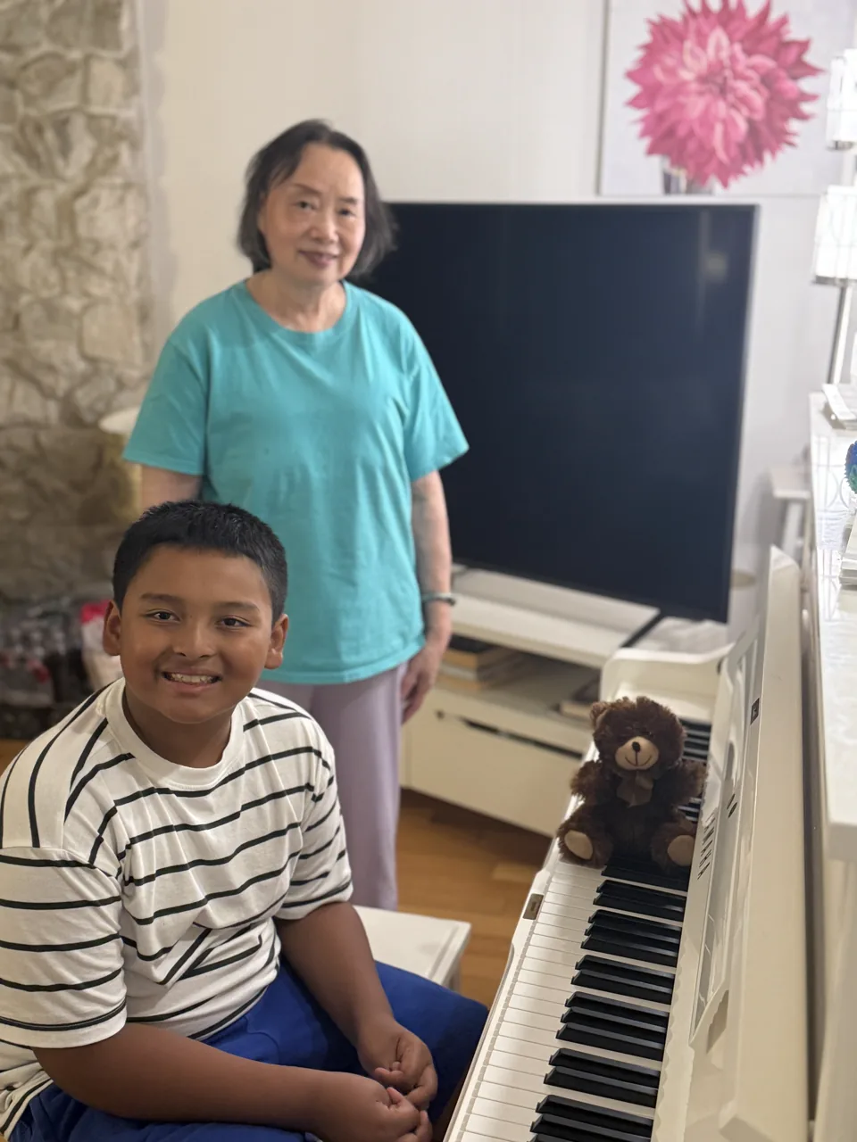 Ray, Grandma, and Mr. Bearry smiling beside the piano
